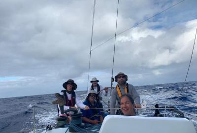 Crew wearing harnesses and flotation mid-ocean